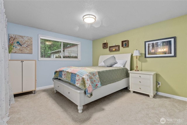 bedroom with light colored carpet and baseboards