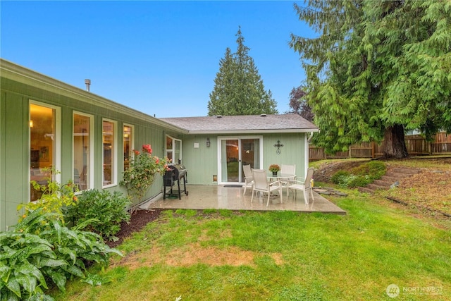 rear view of house with a patio area, fence, and a lawn