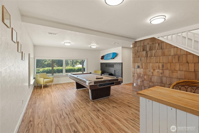 1508 Hoquiam Ln S, Westport, WA 98595 - rec room with billiards, light hardwood / wood-style floors, a tile fireplace, and a textured ceiling