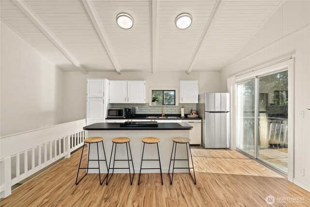1508 Hoquiam Ln S, Westport, WA 98595 - kitchen featuring white cabinetry, light wood-type flooring, a breakfast bar area, and appliances with stainless steel finishes