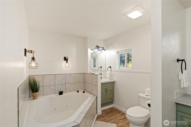 1508 Hoquiam Ln S, Westport, WA 98595 - bathroom featuring vanity, wood-type flooring, a relaxing tiled tub, and toilet