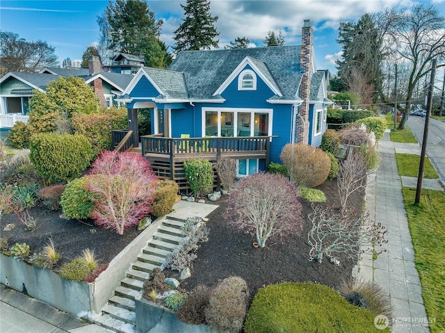 view of front of home with a chimney and a deck