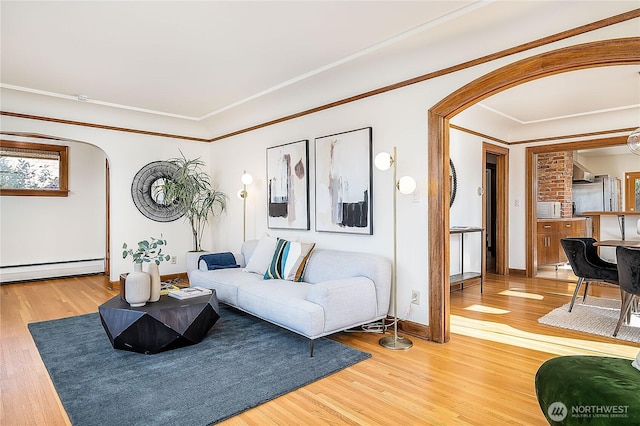 living room with arched walkways, a baseboard radiator, and wood finished floors