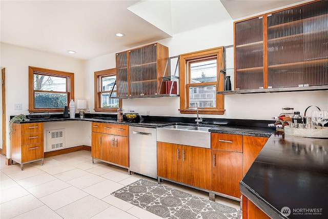 kitchen with visible vents, dishwasher, dark countertops, glass insert cabinets, and brown cabinets