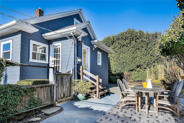 view of patio featuring outdoor dining space, fence, and entry steps