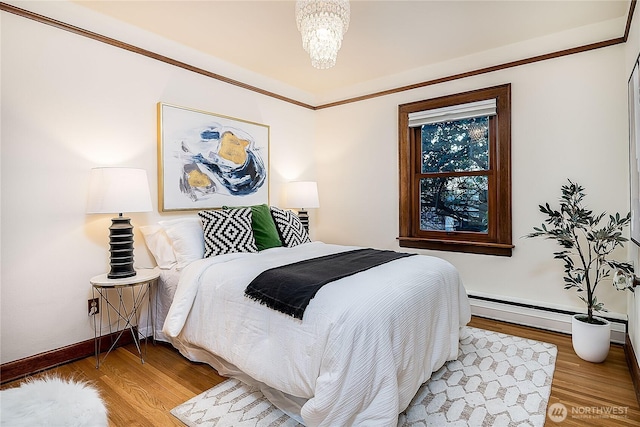 bedroom featuring an inviting chandelier, baseboards, baseboard heating, and wood finished floors