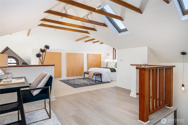 bedroom featuring vaulted ceiling with skylight and light wood finished floors