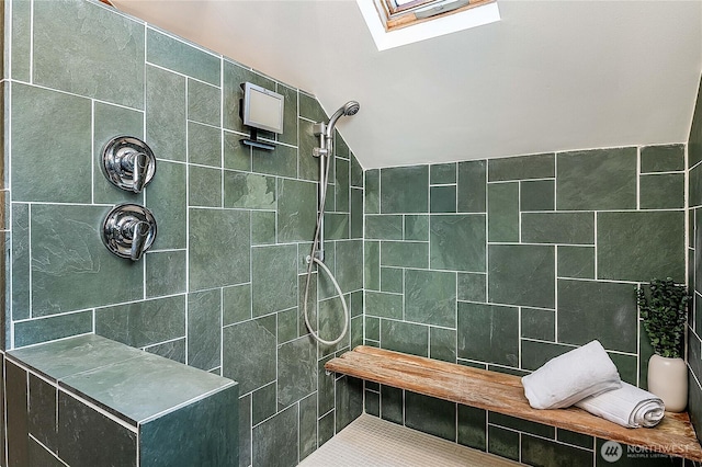 full bath featuring lofted ceiling with skylight and a tile shower