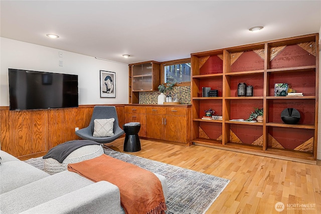 living room featuring light wood-style floors and a wainscoted wall