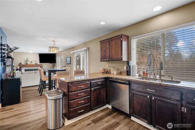 kitchen with sink, dishwasher, decorative light fixtures, kitchen peninsula, and light wood-type flooring