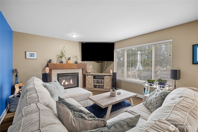 living room featuring a tiled fireplace and hardwood / wood-style floors