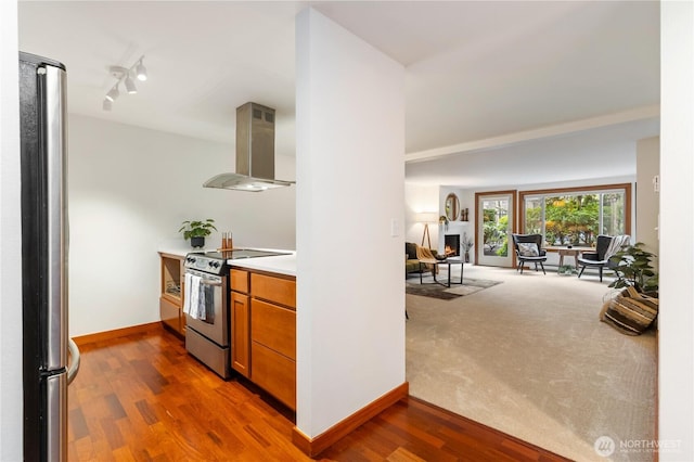 kitchen featuring stainless steel appliances, dark wood-style flooring, open floor plan, brown cabinets, and island exhaust hood