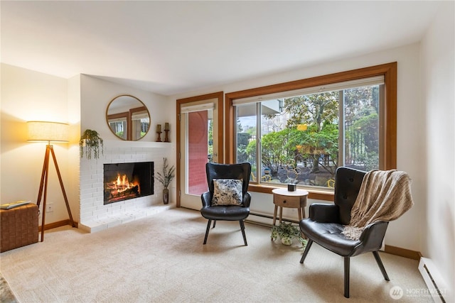 living area featuring a baseboard heating unit, carpet floors, a brick fireplace, and baseboards