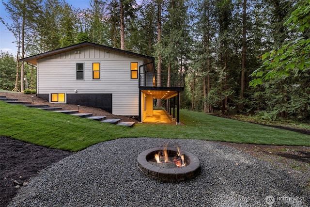 rear view of house featuring a lawn and a fire pit