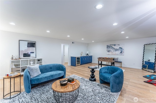 living room featuring light wood-type flooring, beverage cooler, and indoor wet bar