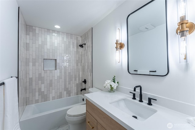 full bathroom with vanity, tiled shower / bath, and toilet