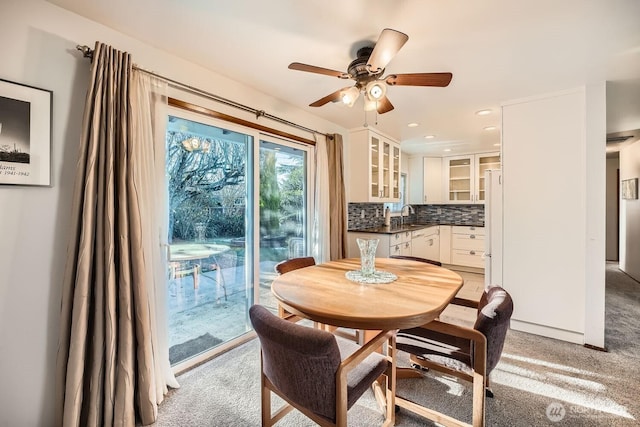 carpeted dining area featuring sink and ceiling fan