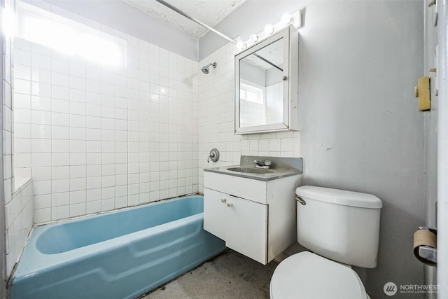 full bathroom featuring vanity, tiled shower / bath combo, and toilet