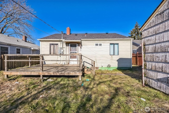 back of house featuring a wooden deck and a yard