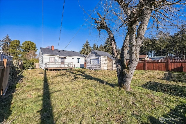 view of yard with a wooden deck and a storage unit