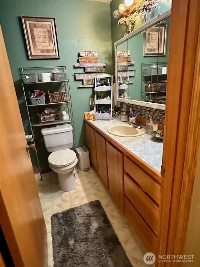 bathroom with vanity, toilet, and backsplash