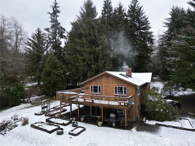 snow covered property with a deck