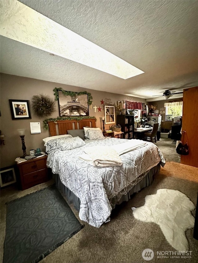 bedroom with carpet, a textured ceiling, and a skylight