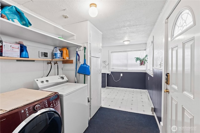 washroom with washing machine and dryer and a textured ceiling