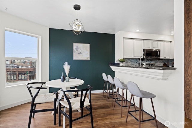 dining area with wood-type flooring and sink