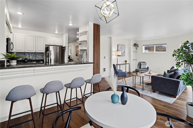 kitchen featuring tasteful backsplash, white cabinetry, appliances with stainless steel finishes, and dark wood-type flooring