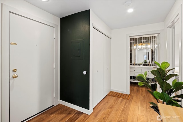 foyer entrance with wood-type flooring and electric panel