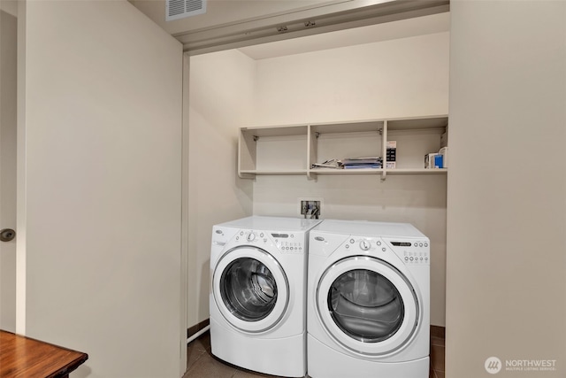 laundry area with dark tile patterned flooring and independent washer and dryer