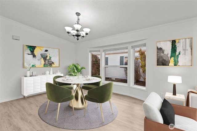 dining space with crown molding, vaulted ceiling, an inviting chandelier, and light hardwood / wood-style floors