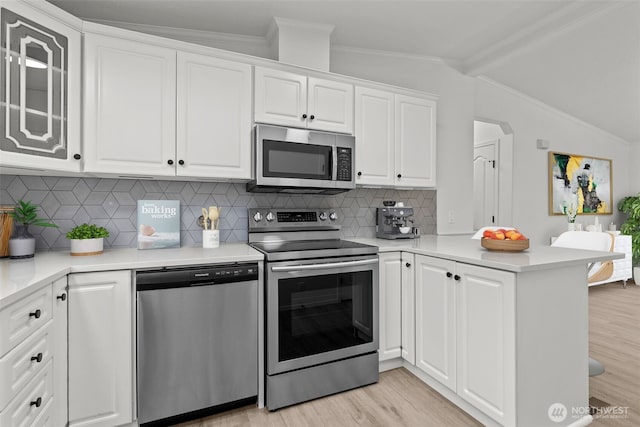 kitchen with white cabinetry, lofted ceiling with beams, light hardwood / wood-style flooring, kitchen peninsula, and stainless steel appliances