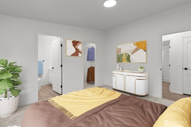 bedroom featuring a walk in closet and ensuite bathroom