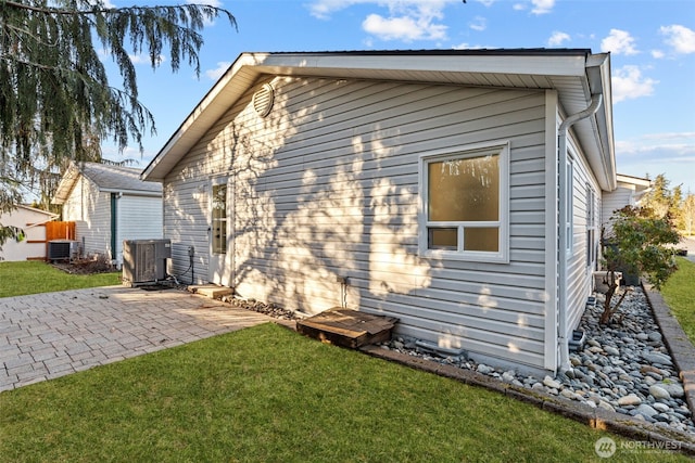 rear view of house with a patio, cooling unit, and a lawn