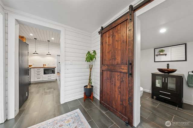 corridor with sink and a barn door