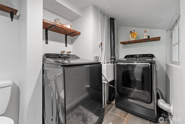 laundry room featuring tile patterned floors and washer and clothes dryer