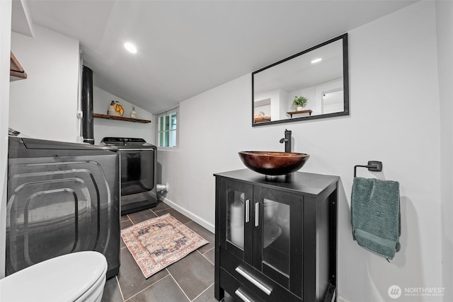 laundry room featuring sink, separate washer and dryer, and dark tile patterned flooring