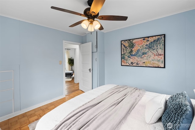 bedroom featuring ceiling fan, ornamental molding, and light parquet flooring