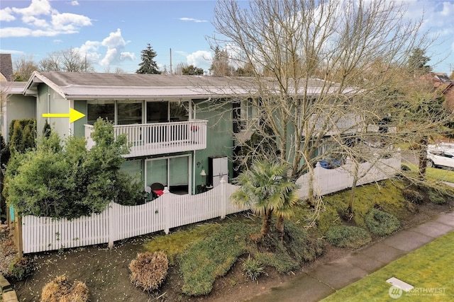 view of front of home with a balcony and fence