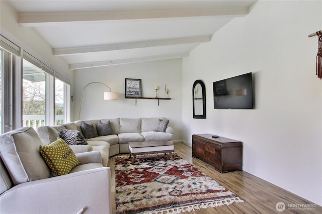 living area featuring lofted ceiling with beams and light wood-type flooring