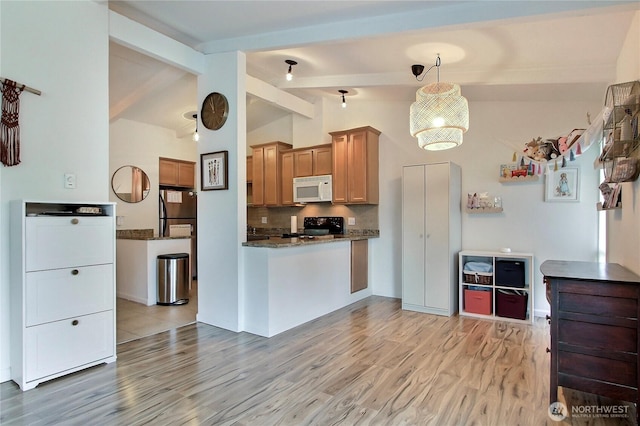 kitchen featuring lofted ceiling with beams, white microwave, light wood-style flooring, black range with electric stovetop, and pendant lighting