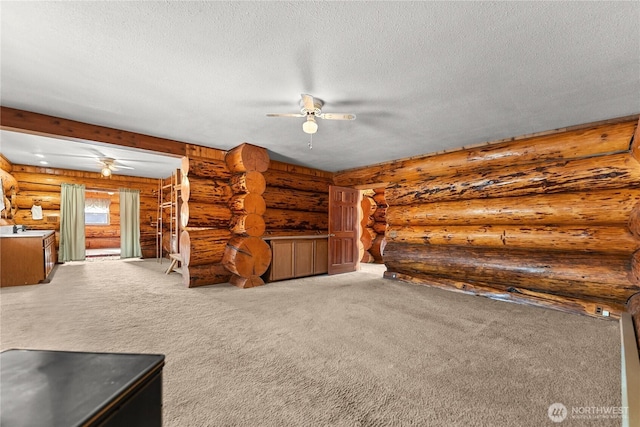 unfurnished living room with ceiling fan, carpet, and a textured ceiling