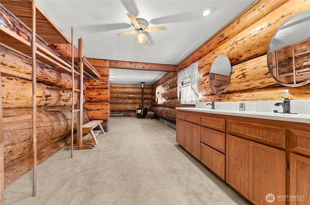 interior space featuring a sink, log walls, ceiling fan, and double vanity