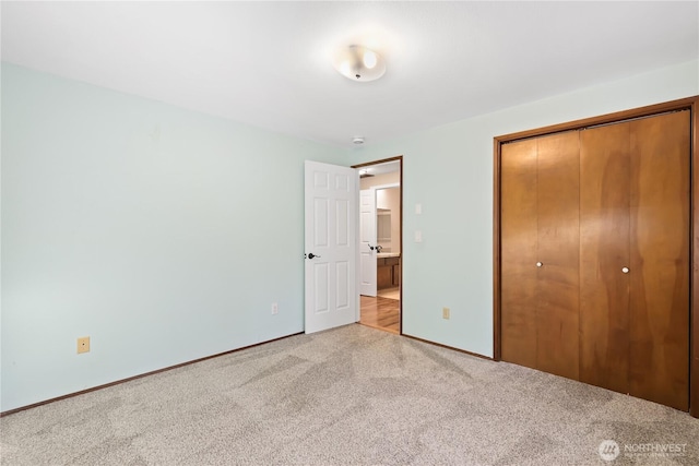 unfurnished bedroom featuring light carpet and a closet