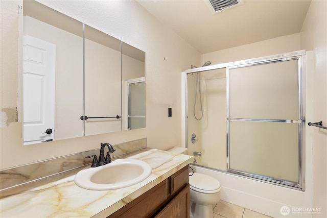 full bathroom with tile patterned floors, toilet, vanity, and combined bath / shower with glass door