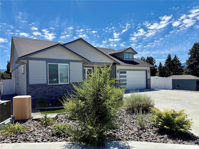 2764 N Breckenridge Dr, East Wenatchee, WA 98802 - view of front of house with central air condition unit, driveway, stone siding, a garage, and a gate