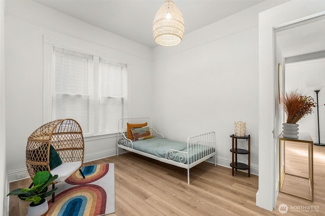 bedroom featuring wood finished floors and baseboards