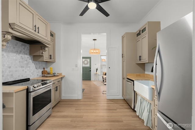 kitchen with tasteful backsplash, light wood-style flooring, stainless steel appliances, light countertops, and ceiling fan with notable chandelier